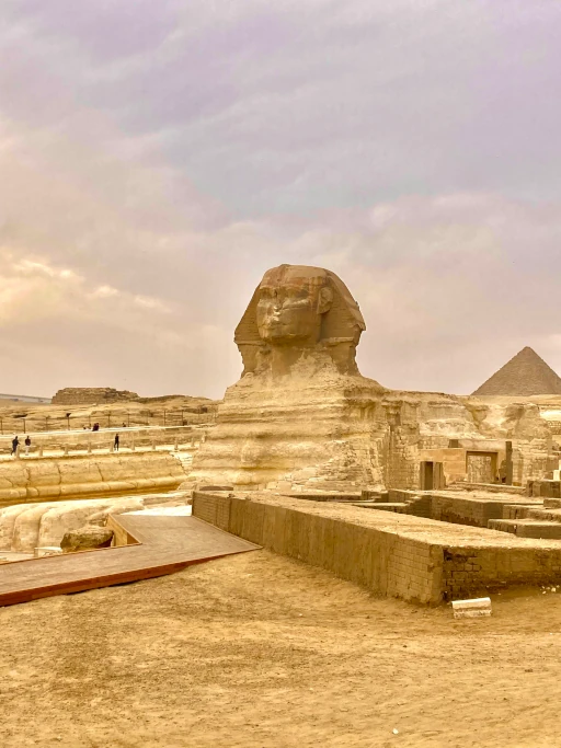 A Photo of the Great Sphinx with a pyramid in the background, in Giza, Egypt